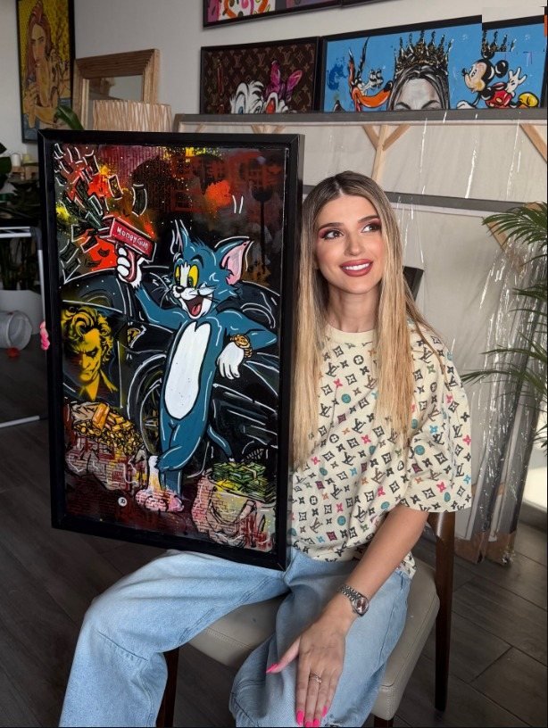 Oana Cocindau in her studio with one of her paintings